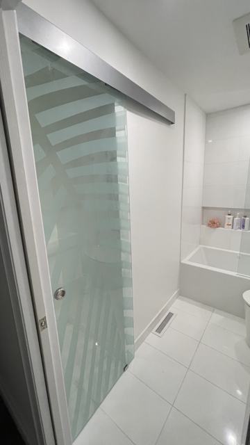 Tiled shower with a sliding glass enclosure