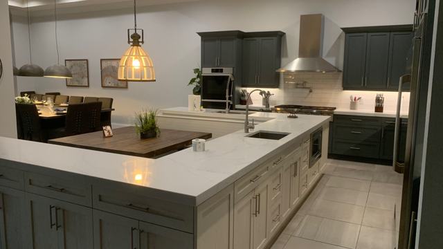Kitchen island with light cabinetry and pendant lighting