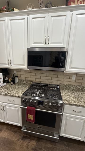 White kitchen cabinets, backsplash and range installation