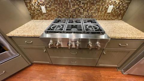 Stainless range, stone countertops and tile backsplash